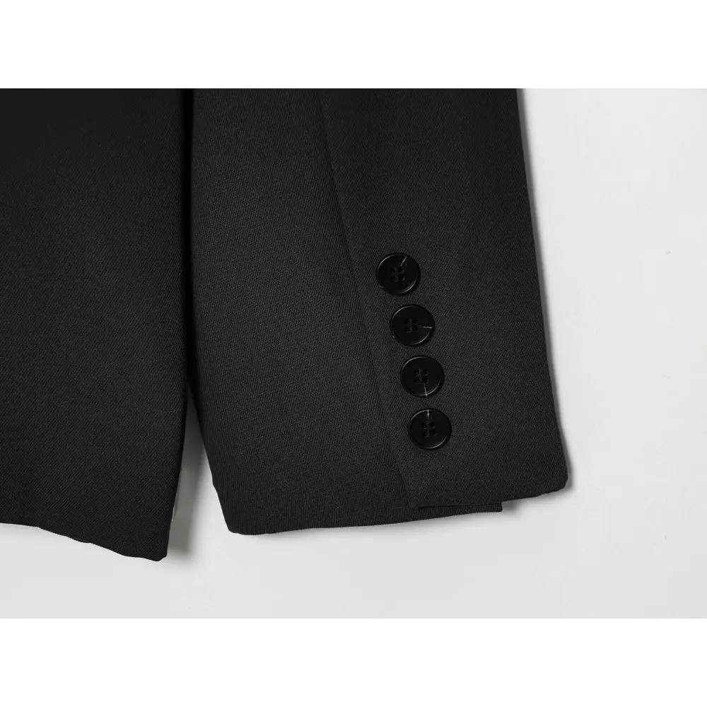 Close-up of black sleeve cuff with four buttons