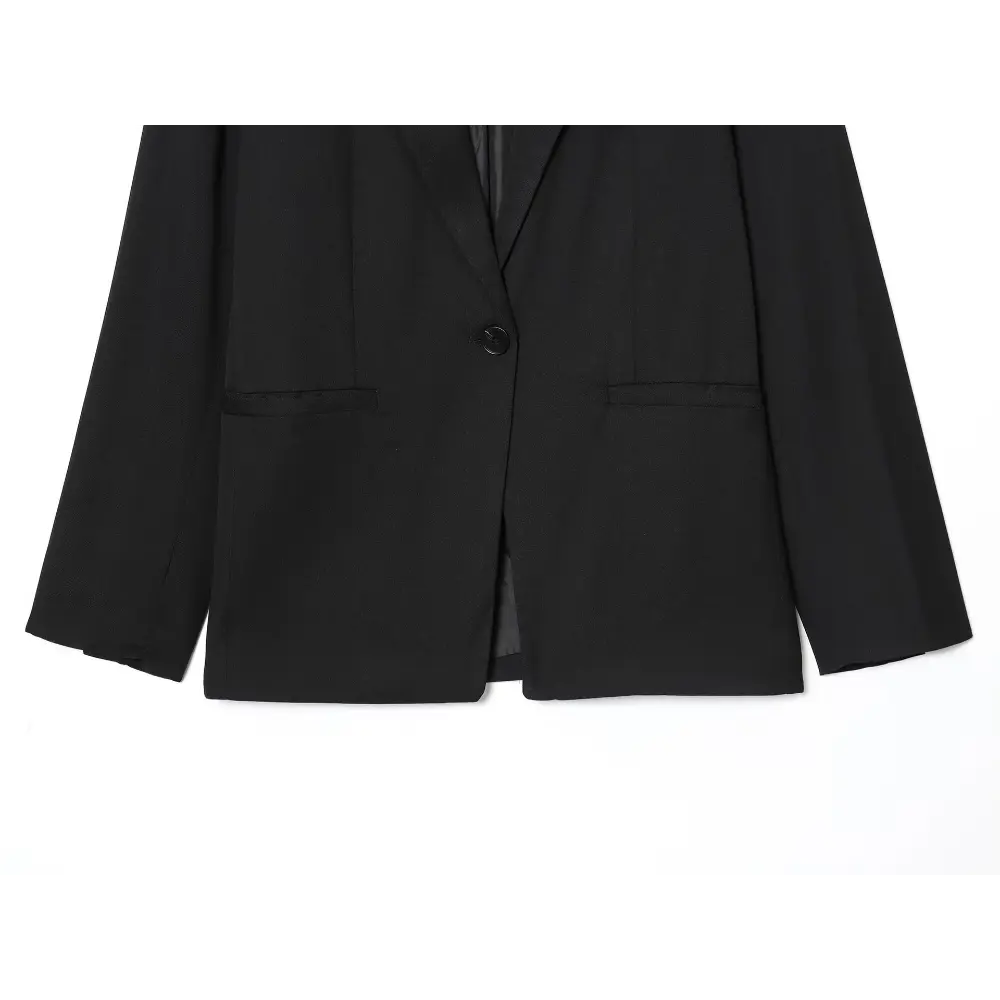 Close-up of black blazer front, button and welt pockets