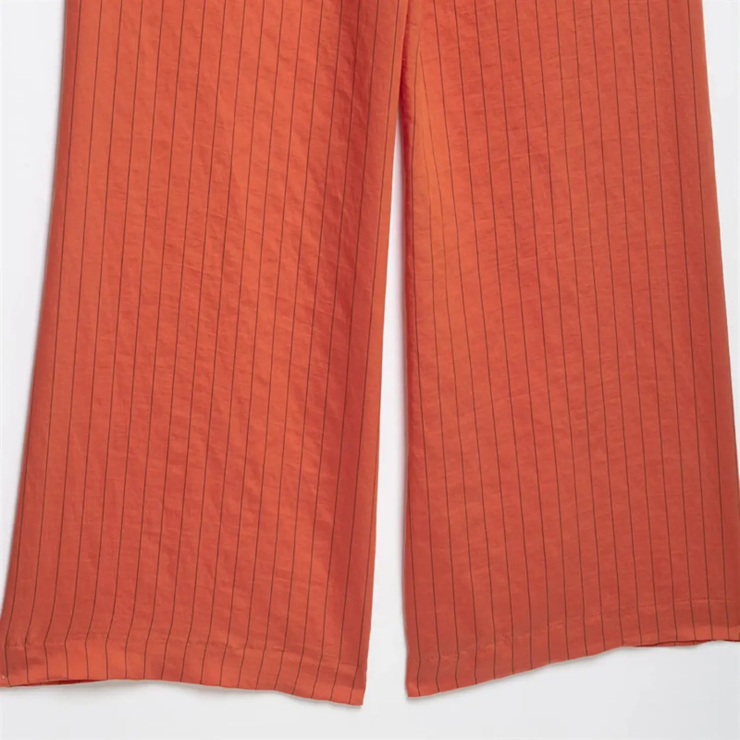 Single trouser leg partial shot, natural fabric soft crease, continuous vertical pinstripe pattern, lightweight breathable textile