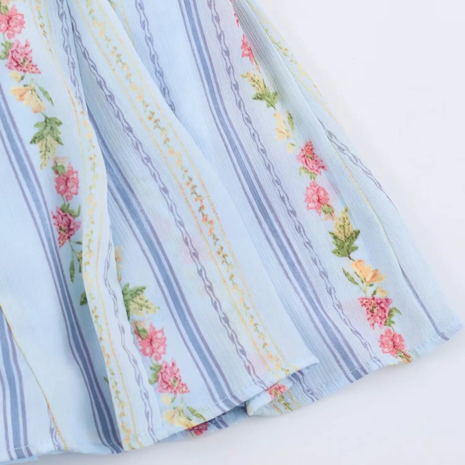 Skirt hem partial close-up, vertical stripe mixed pink flower print crinkle fabric, finished hem edge