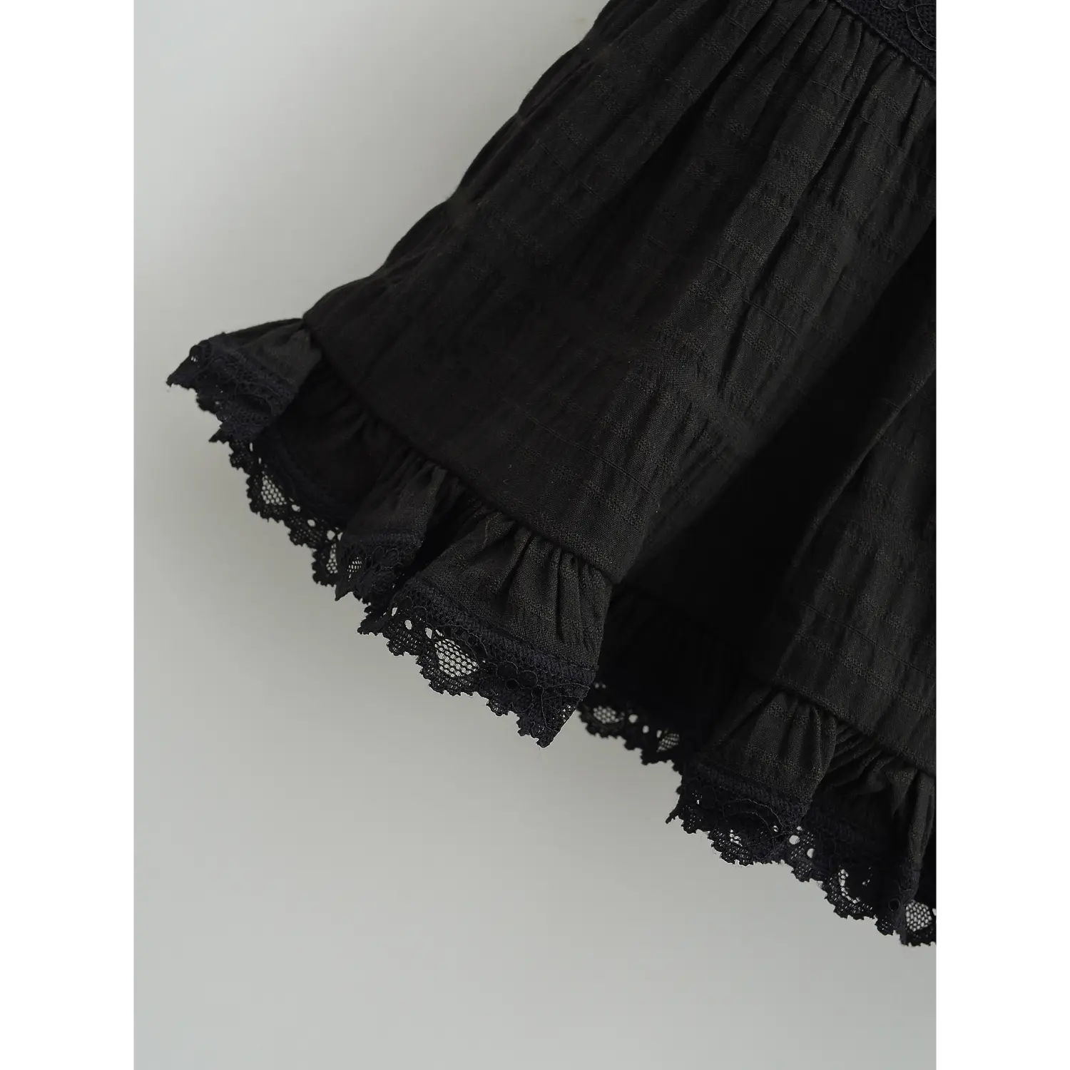 Cake skirt bottom double layer wavy eyelet lace hem macro close-up, ruffle hem overlay lace double serging anti-fray goth sweet hem detail shot
