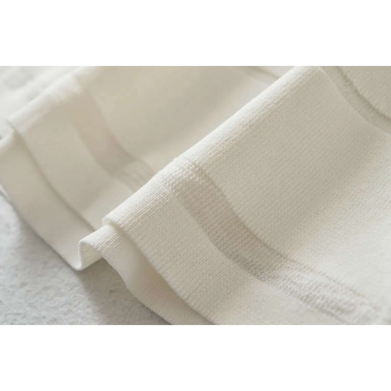 Dress hem knit binding macro close-up, flat neat serging vertical rib stretch knit anti-deformation hem sewing detail shot