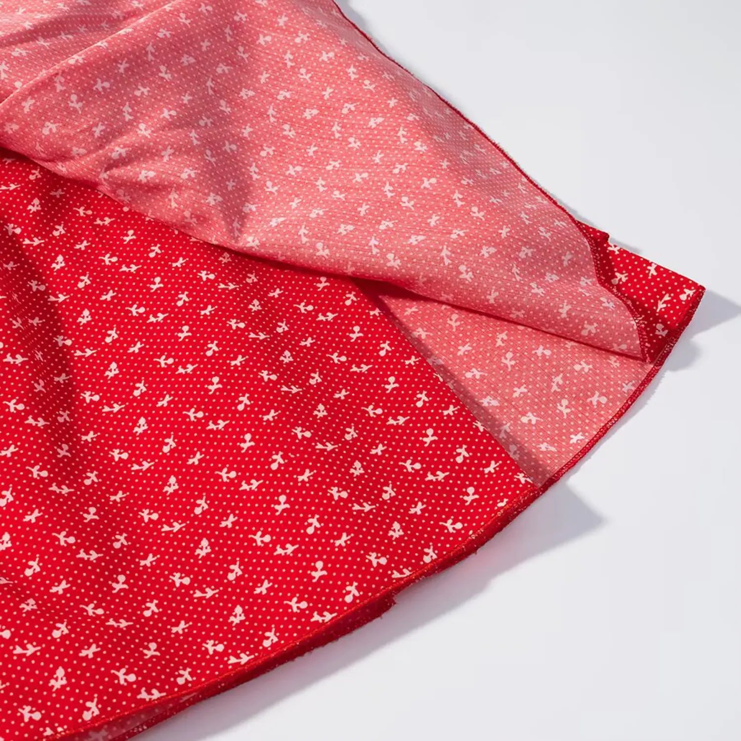 Close‑up showing outer shell and inner lining of red floral ruffle skirt