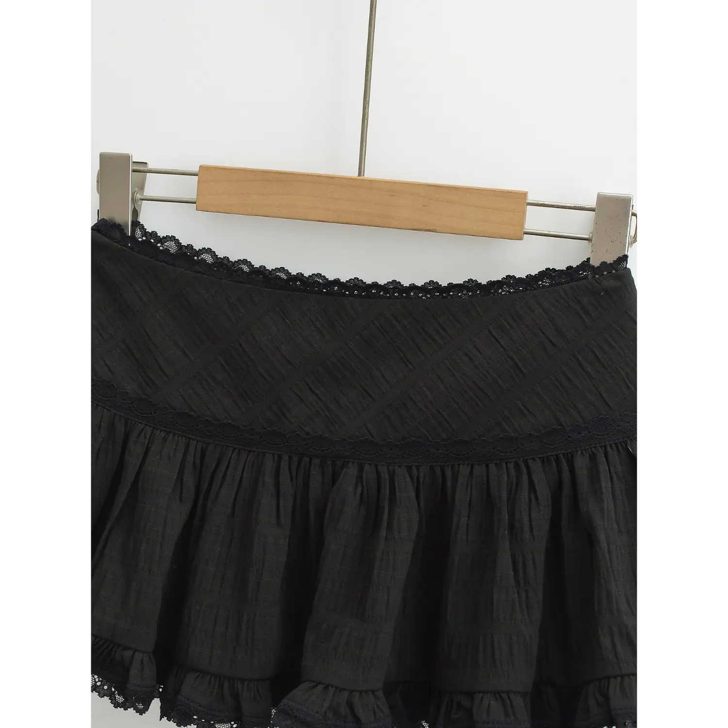 Black mini skirt waist lace splicing close shot, full circle wavy eyelet lace on waist edge smooth diamond textured fabric waist lace dividing line detail shot