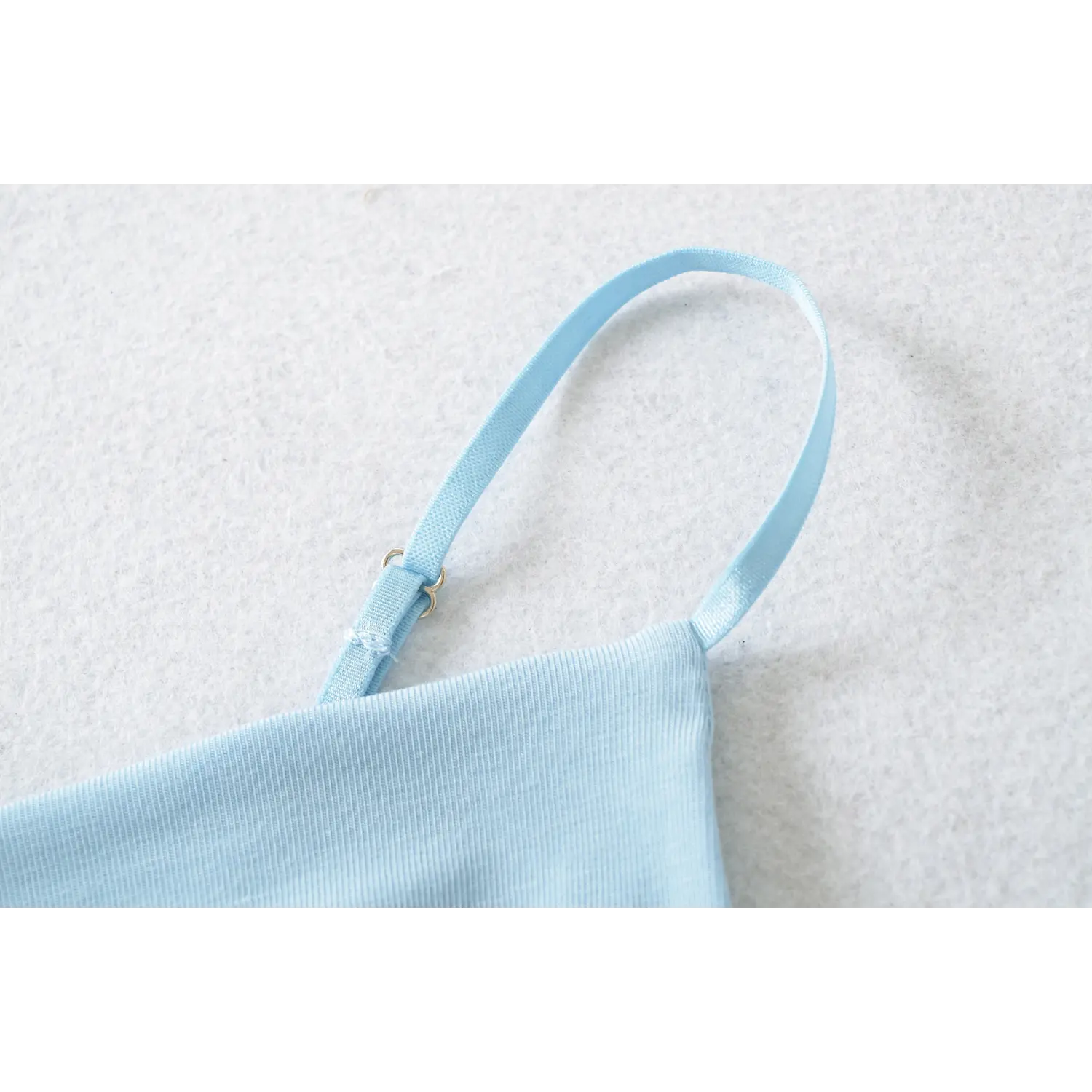 Close up shot light blue ribbed cami adjustable thin strap, silver double ring metal slider, fine rib knit fabric texture