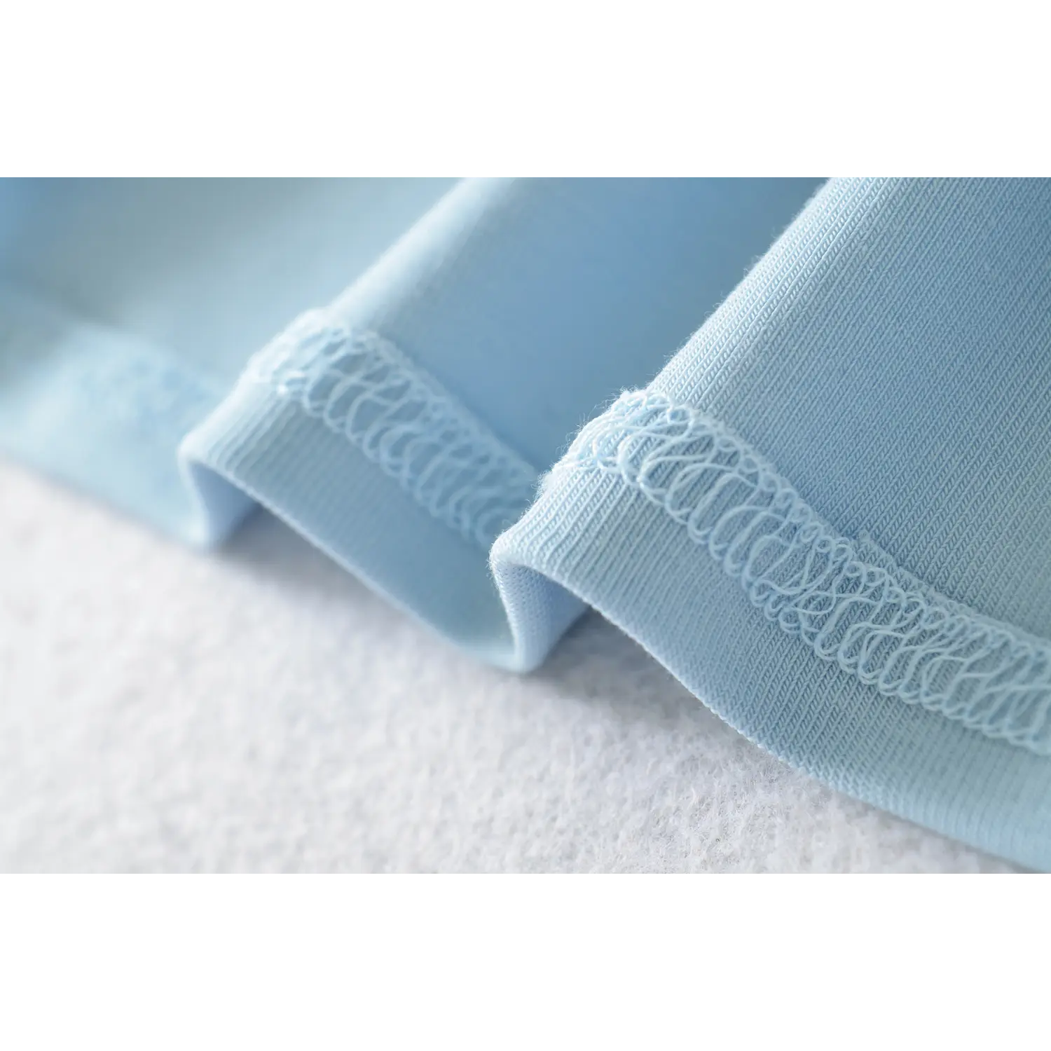 Inside detail shot light blue ribbed singlet hem, delicate wave elastic lace trim inner lining fine rib knit