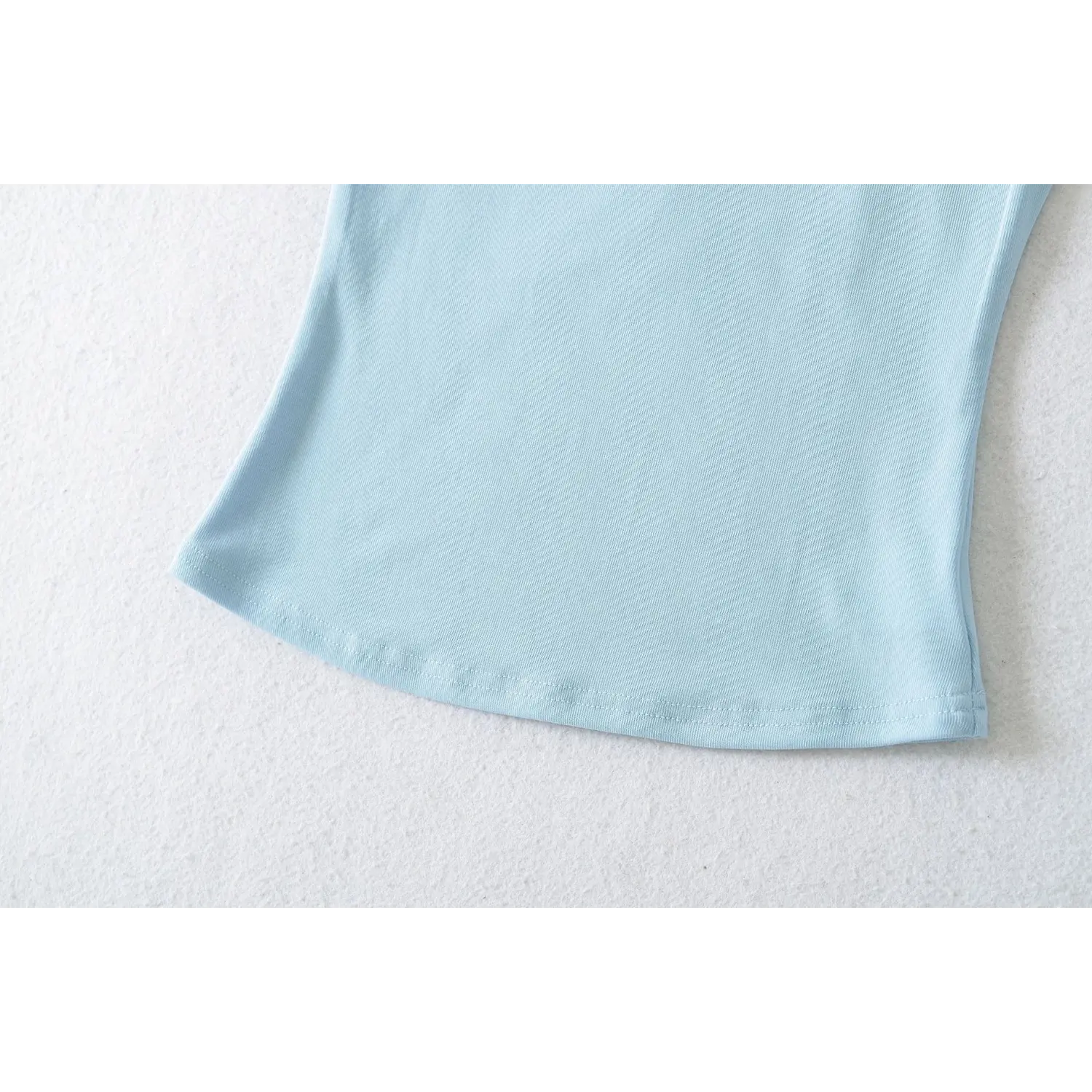 Side detail light blue bodycon camisole curved hem, tidy even stitching stretch rib knit contour cut bottom edge