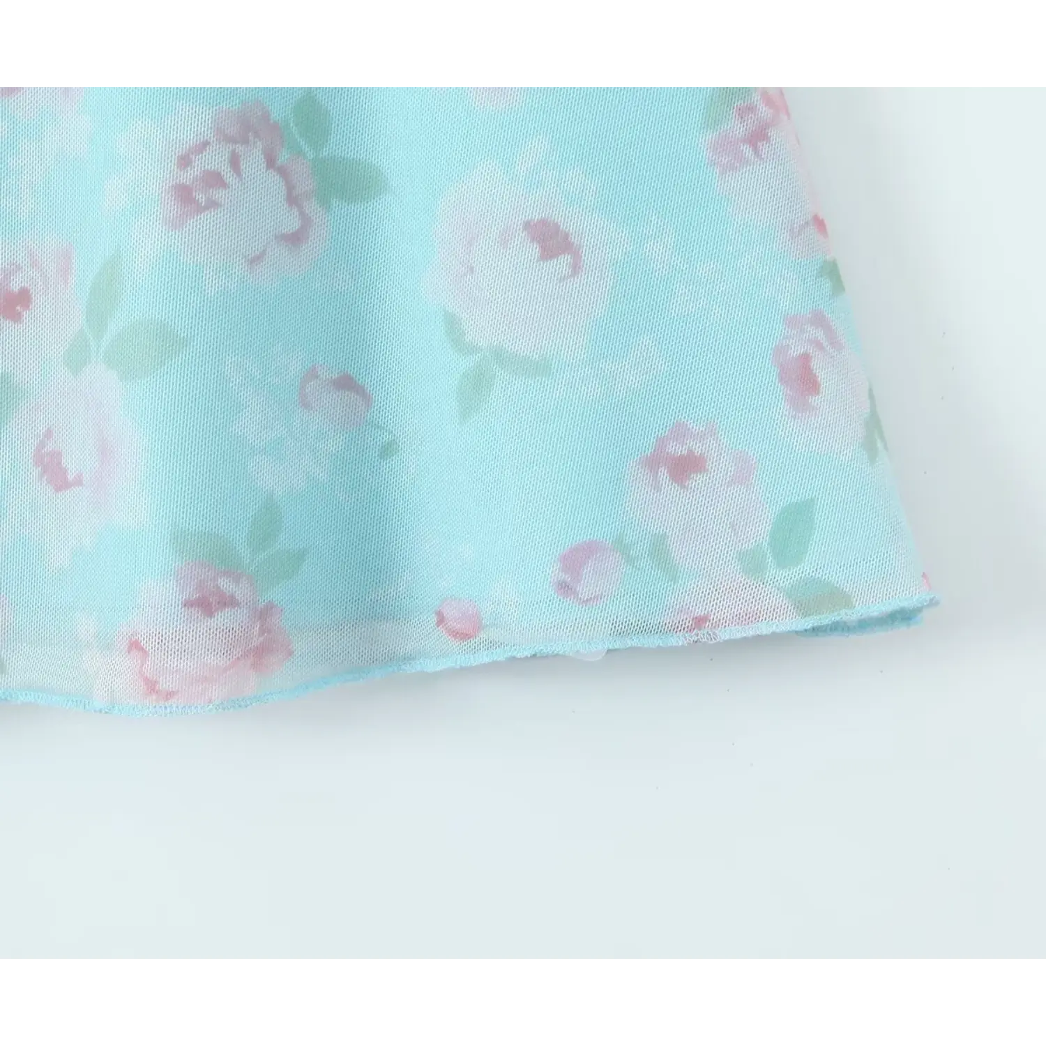 Close‑up of mesh skirt hem with rose floral print for skyblue camisole mini dress