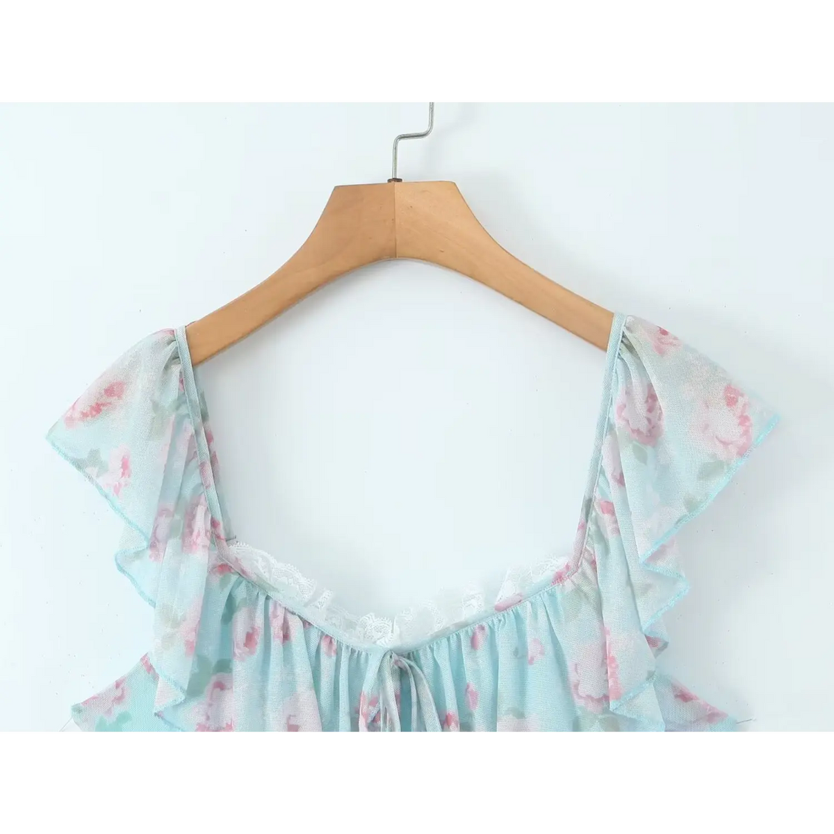 Close‑up on wooden hanger, ruffle lace trim neckline of skyblue rose floral mesh mini dress