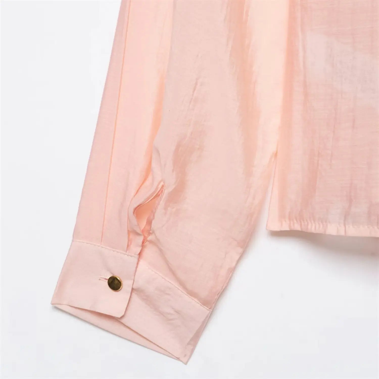 Sleeve cuff close-up, small round gold metal button, sleeve upper gathering pleats, folded cuff binding