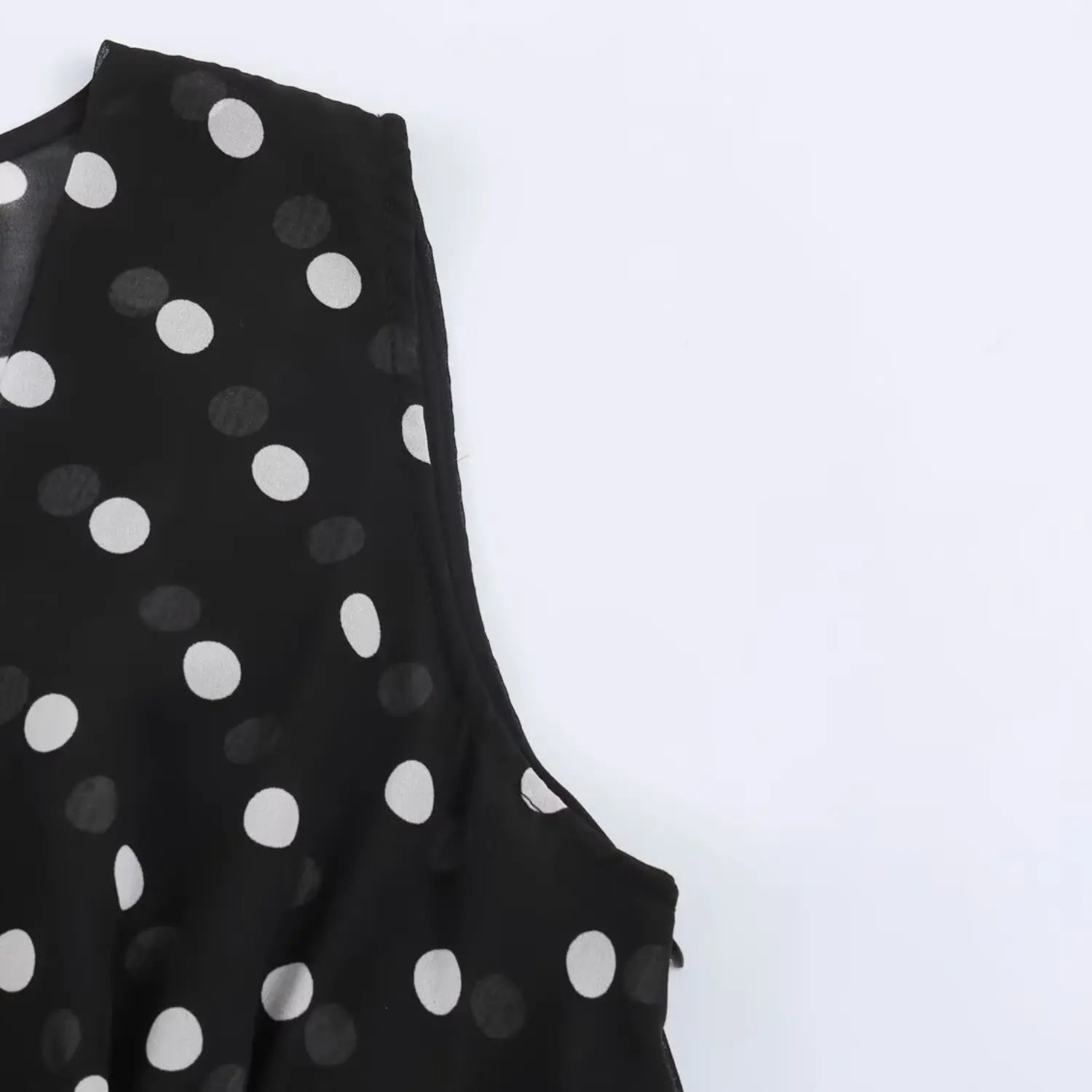 Sleeveless armhole close-up, neat finished piping edge, see-through polka dot woven texture