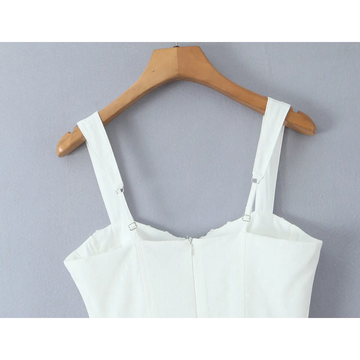 Shoulder strap detail, wide matching fabric strap with dual metal adjuster, clean finished neck seam on white coquette dress.