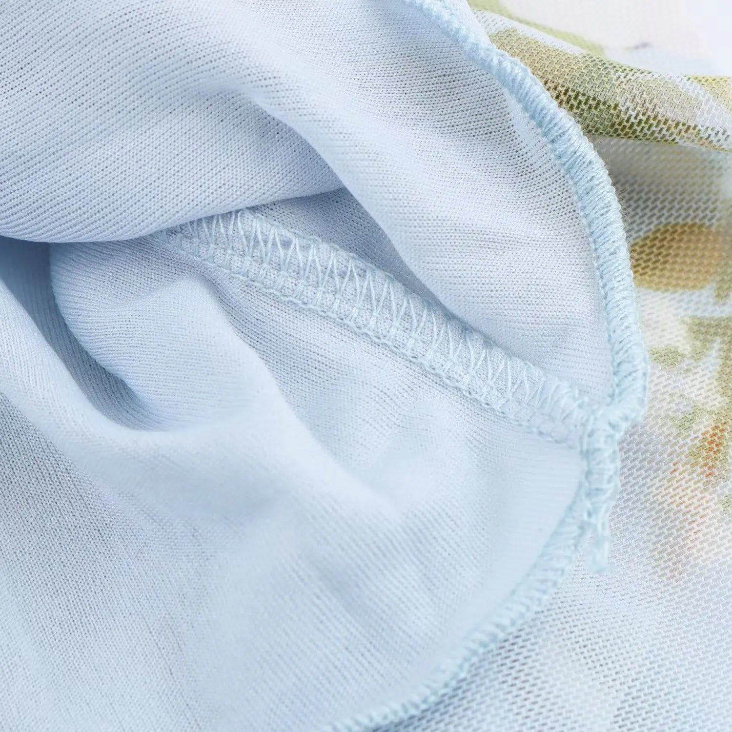 Close‑up of soft interior lining and neat finished stitching of light blue floral mesh mini dress