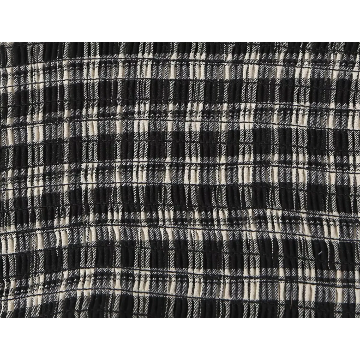 Extreme close-up stretch smocked black white plaid fabric, fine woven grid texture, breathable lightweight cotton blend blouse material