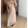 Indoor mirror full shot of pale peach micro floral spaghetti strap maxi dress, smocked elastic bust waist, flowy sheer floor-length skirt, paired with dark brown pointed leather ankle boots