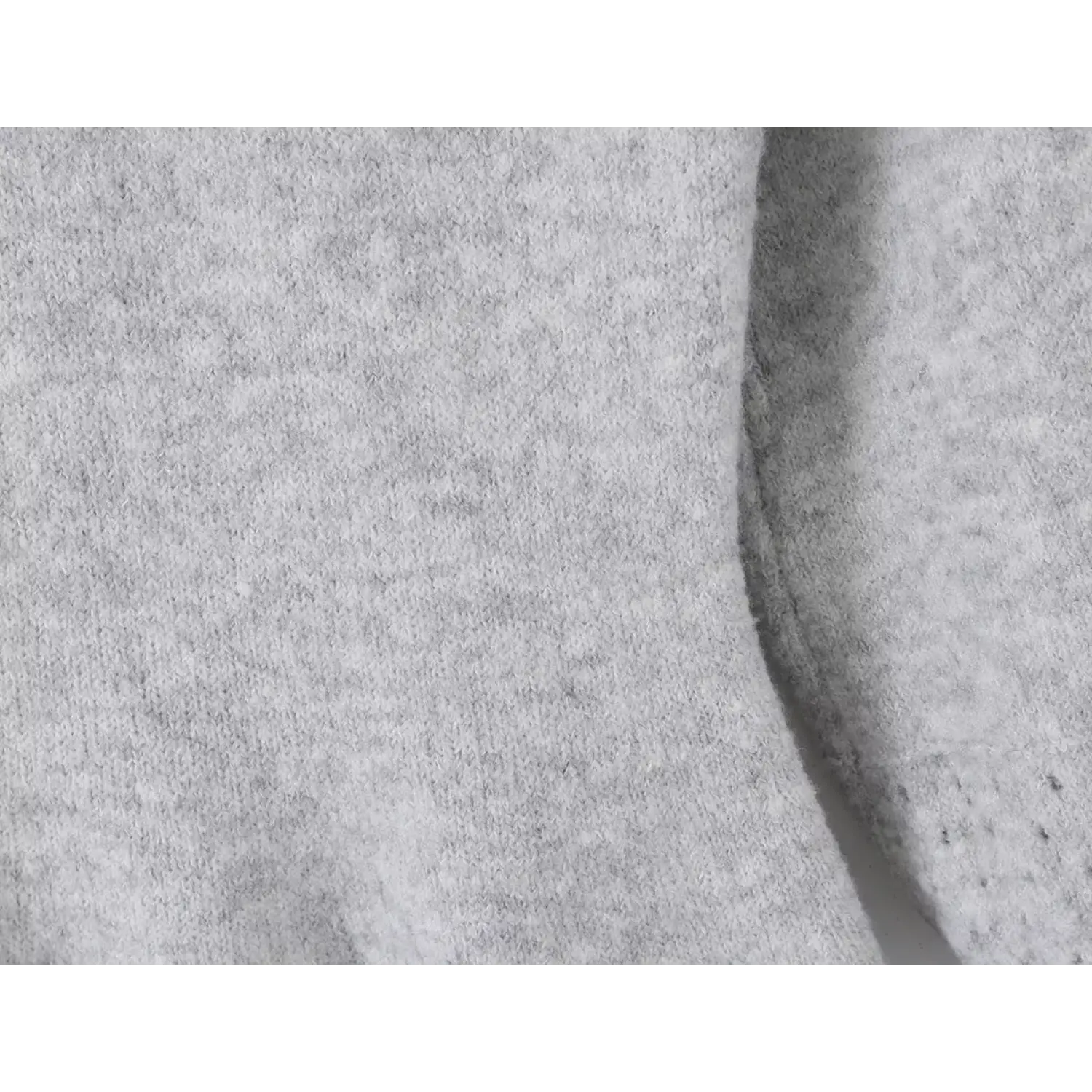 Extreme close up texture shot of fuzzy soft heather grey knit fabric for women mini sweater dress