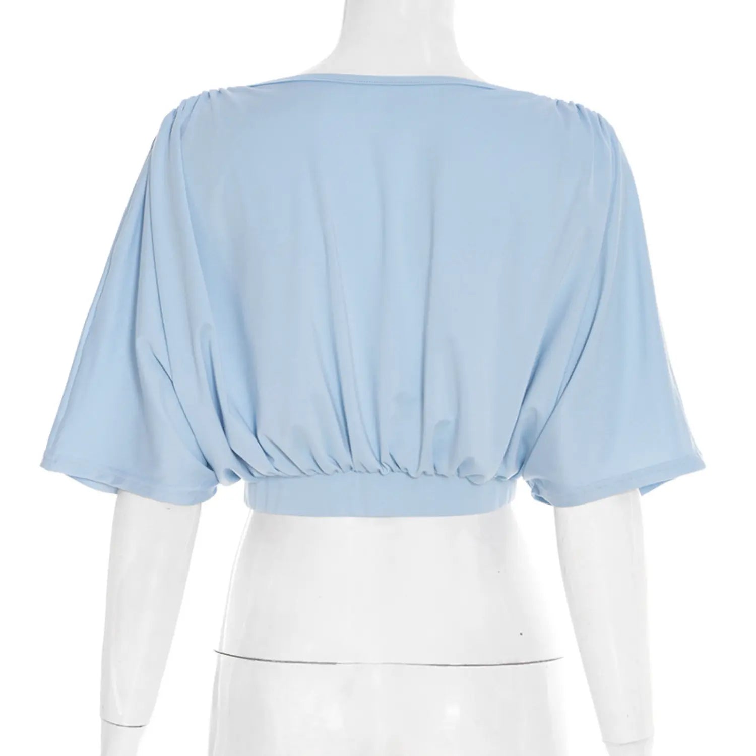 Full back white studio mannequin shot of wrap front cropped blouse, solid sky blue lightweight stretch jersey, gathered ruched detailing across upper back, oversized batwing dolman short sleeves, wide matching elastic cropped waist hem