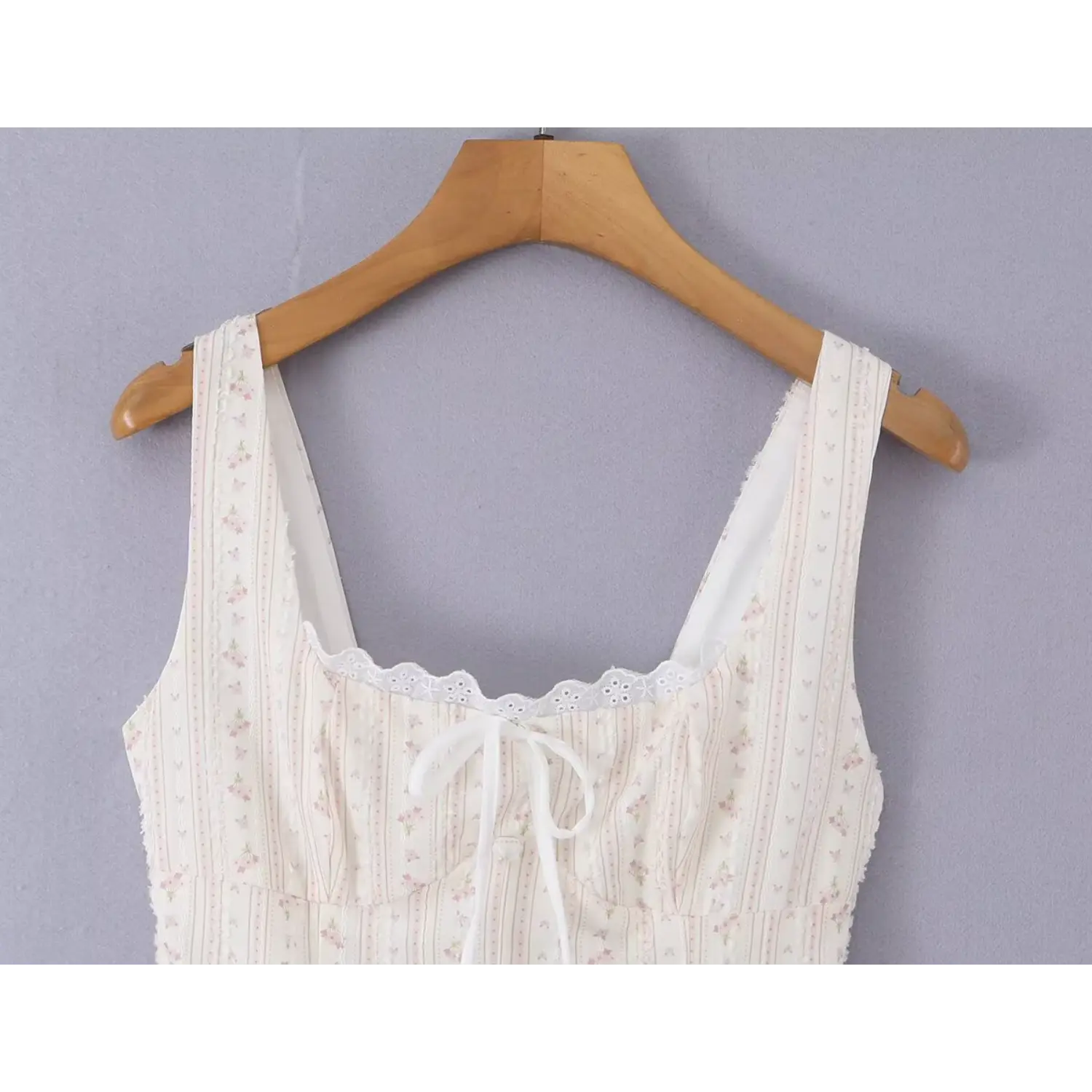 Bust partial shot square neck cami dress, scalloped hollow eyelet lace trim, center front soft fabric tie bow, vertical pink mini floral textured woven material