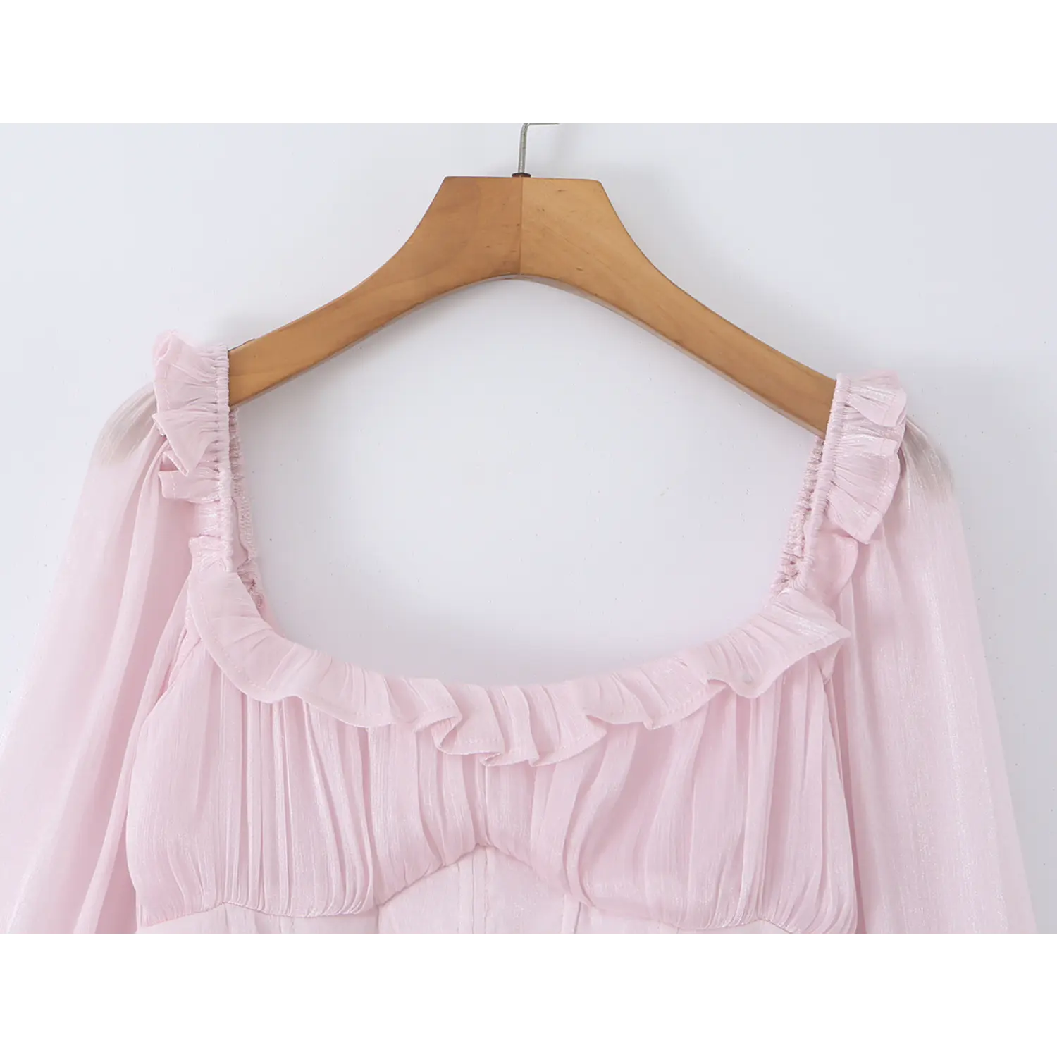 Neckline and bust close-up, square ruffle trim, gathered bust fabric, soft sheer chiffon folds, pale pink romantic detail