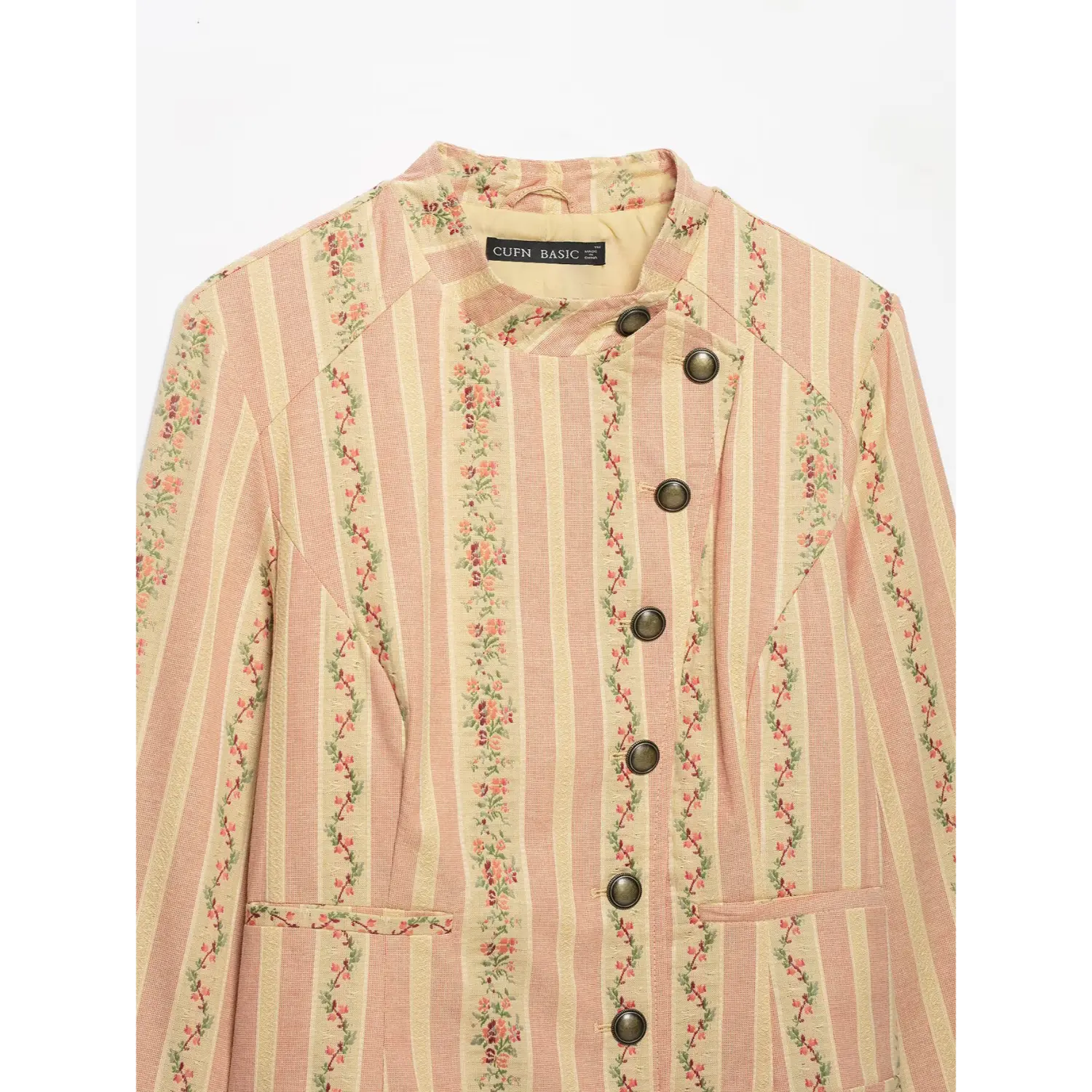 Close-up front view stand collar, asymmetrical antique brass button placket, inner label and floral stripe jacket