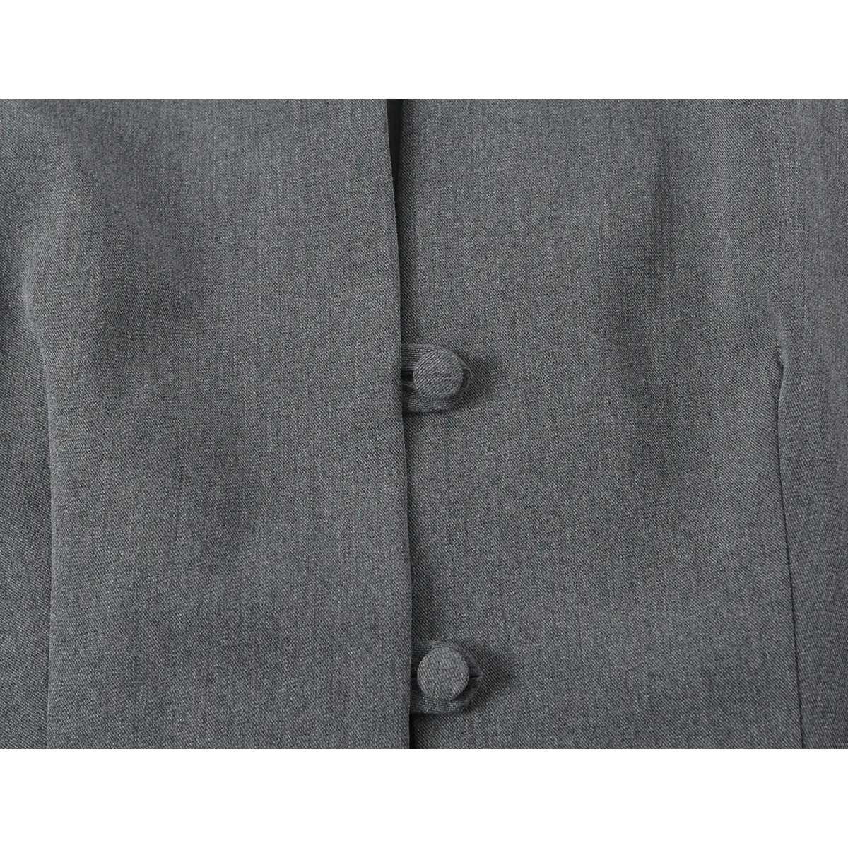 Close-up of fabric-covered buttons on front placket