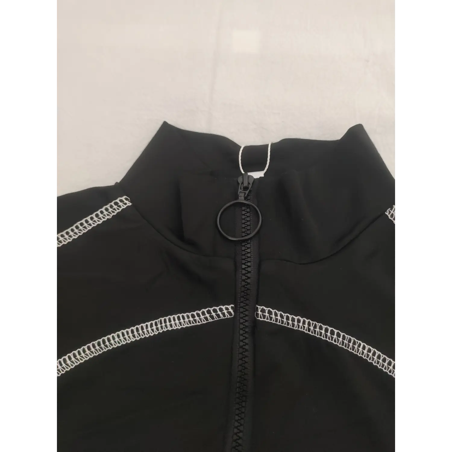 Close-up stand collar and circular ring pull half zipper of black contrast stitch crop top