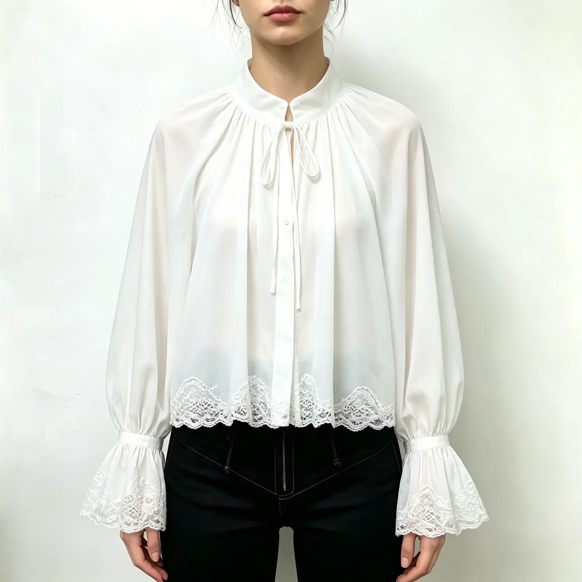 Model wearing white stand collar tie neck lace trim bell sleeve blouse with black trousers