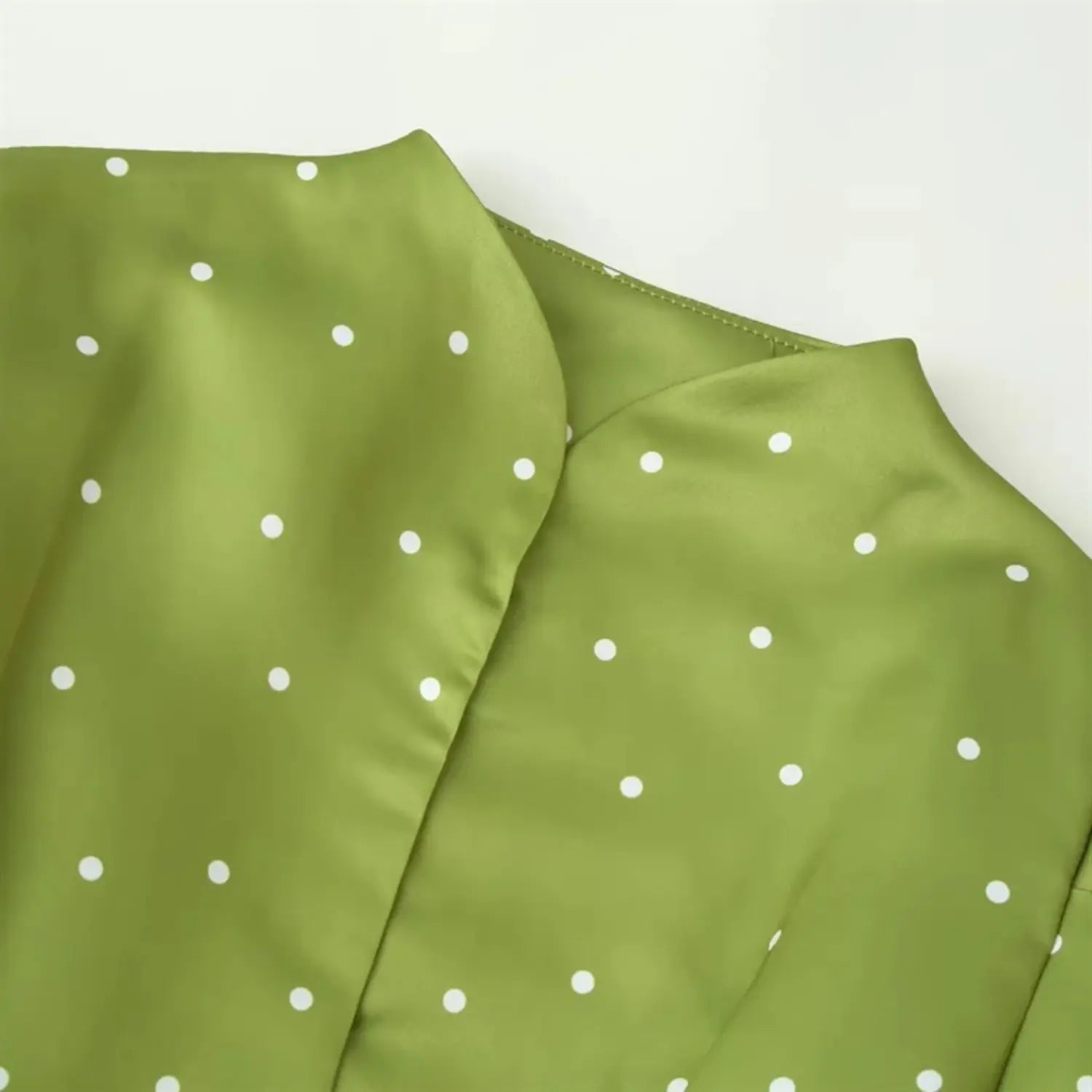 Partial close-up of split stand collar, folded neat binding stitching, smooth shiny satin texture, evenly arranged white dots