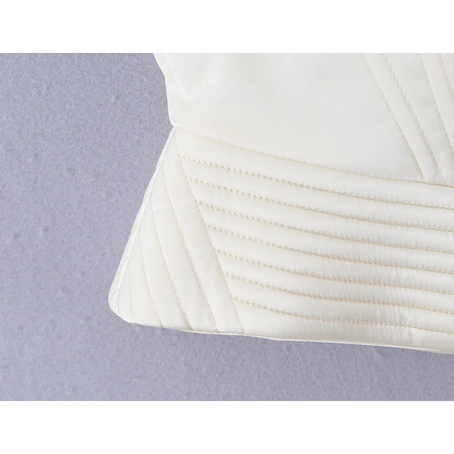 Horizontal stitched hem detail at waist hem of white satin bustier corset cami, structured shaping