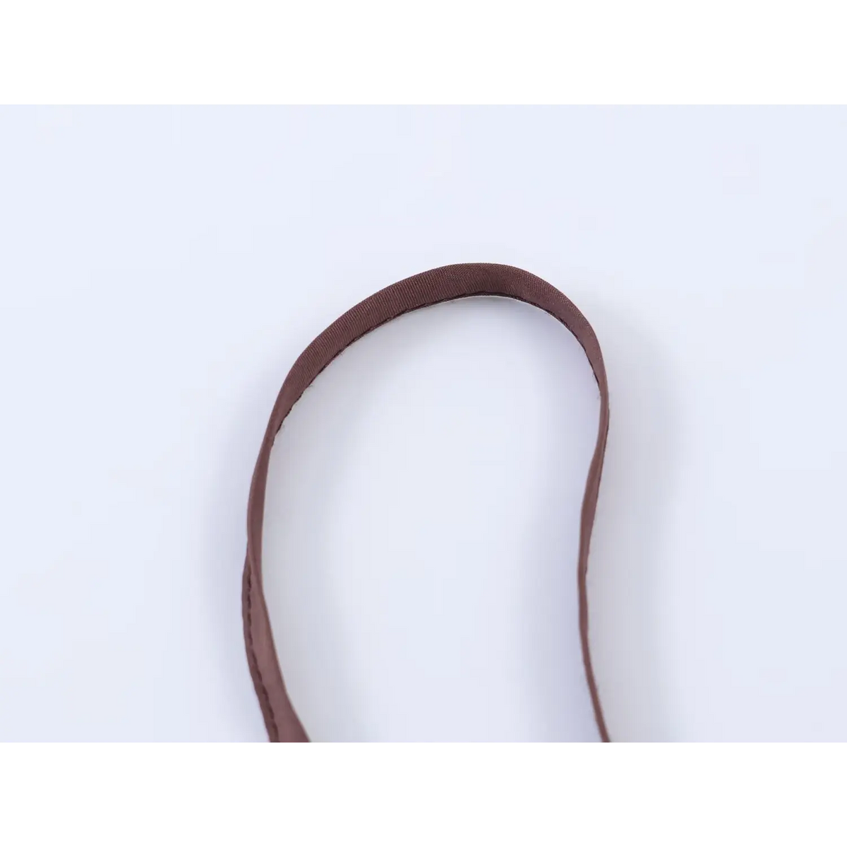 Macro close-up of brown spaghetti strap edge and fine stitching on polka dot maxi dress
