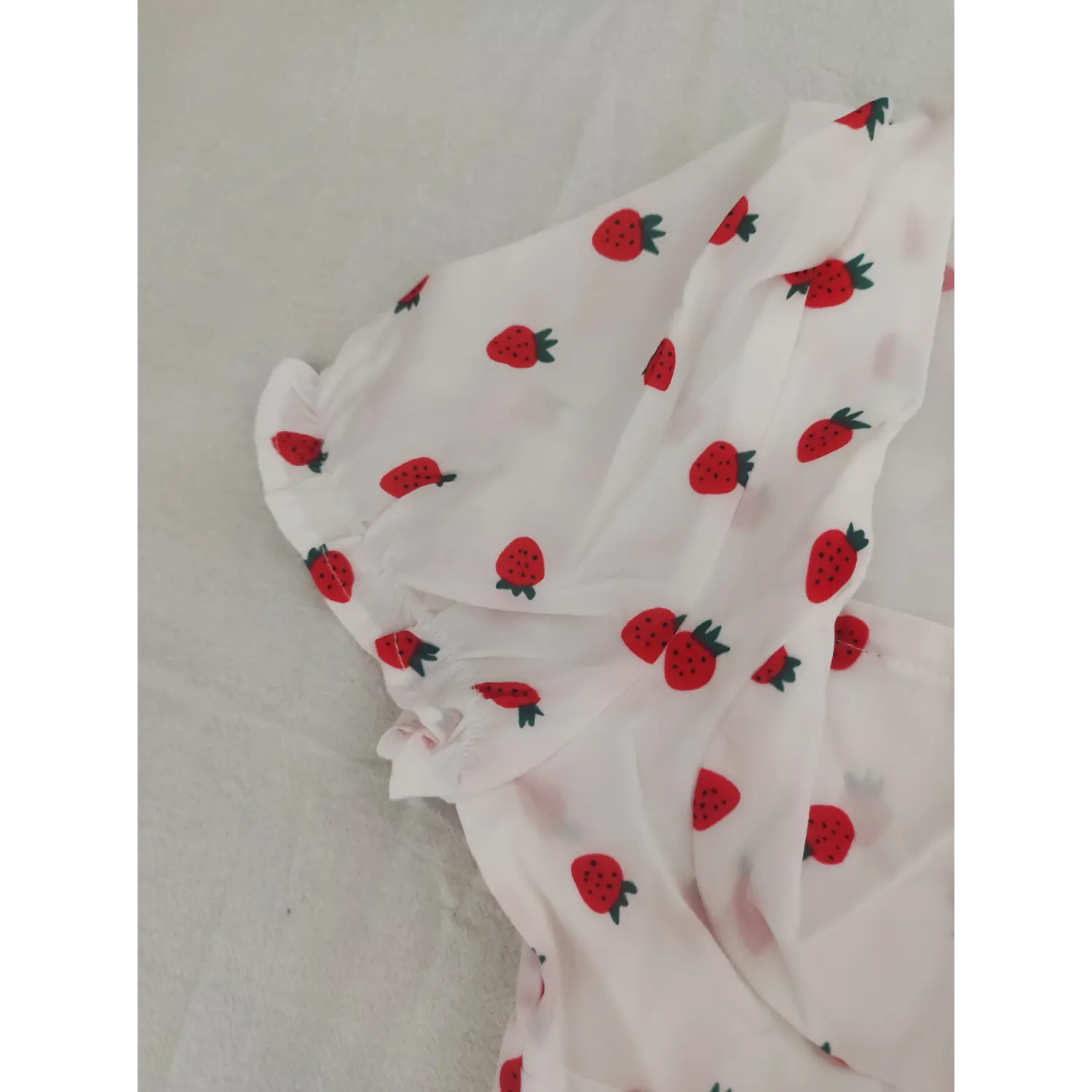 Close-up puff short sleeve ruffle hem of strawberry print white crop top