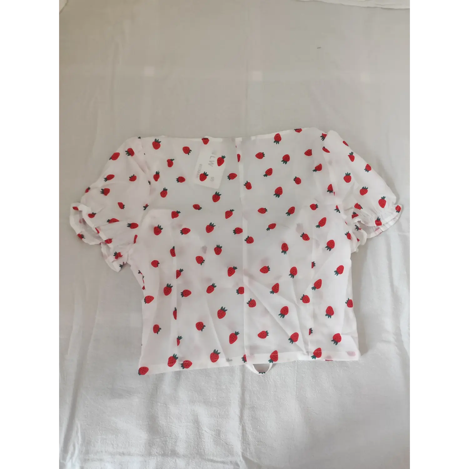 Flat lay back view white strawberry printed cropped blouse with back zipper