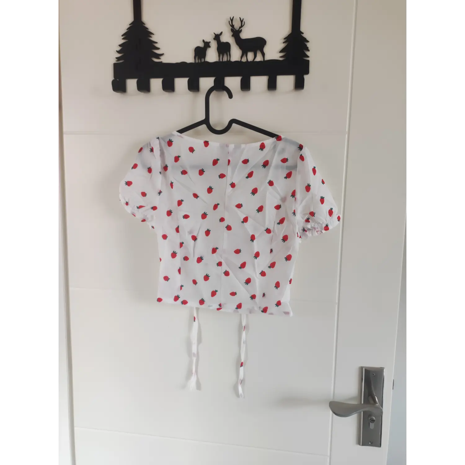 Hanging back view white strawberry printed puff sleeve crop top on clothes hanger