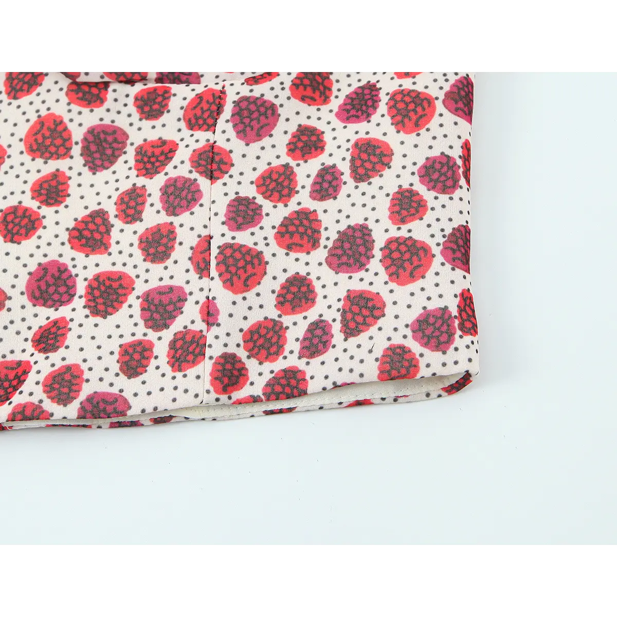 Hem view of the strawberry print halter top, showing the finished edge and fabric lining