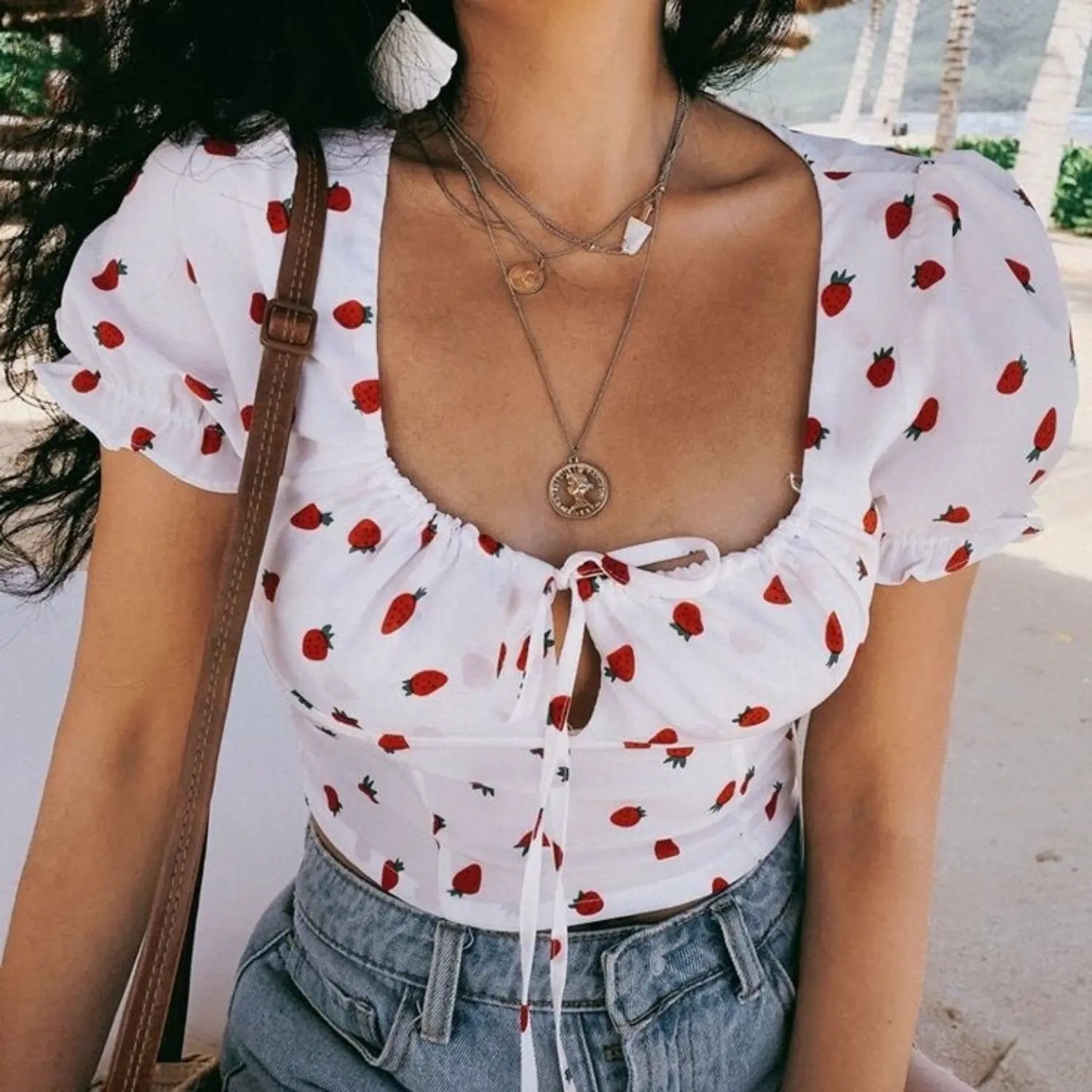 Outdoor model front photo white crop top with red strawberry print square neck puff sleeve tie front blouse