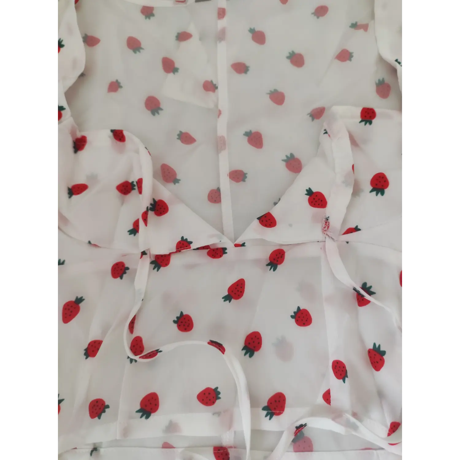 Close-up shot front tie and bust stitching detail strawberry print cropped blouse