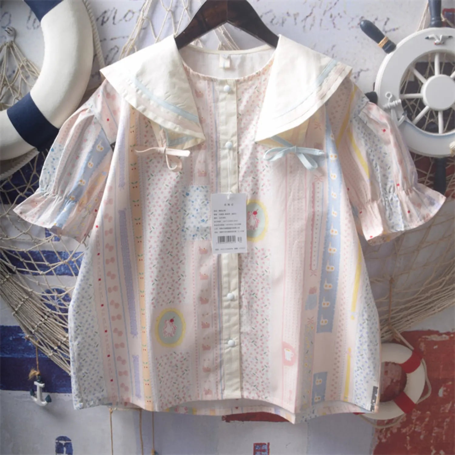 Strip cartoon print sailor collar puff short sleeve blouse hanging shot, double contrast sailor lapel dual color shoulder bows front white buttons elastic ruffle bubble short sleeve summer girl loose printed shirt lifestyle display
