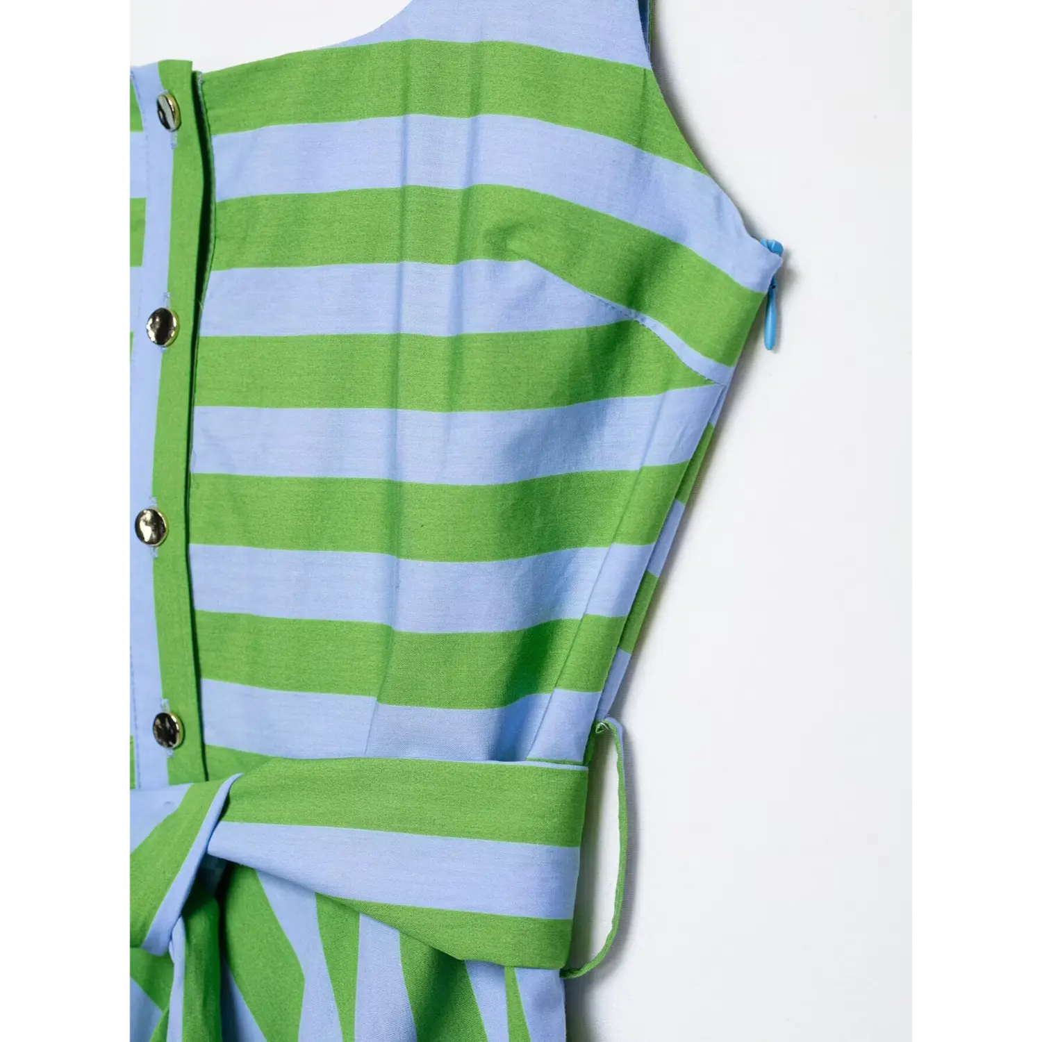Close-up of front button placket, shoulder strap and waist belt detail on green blue stripe sleeveless dress