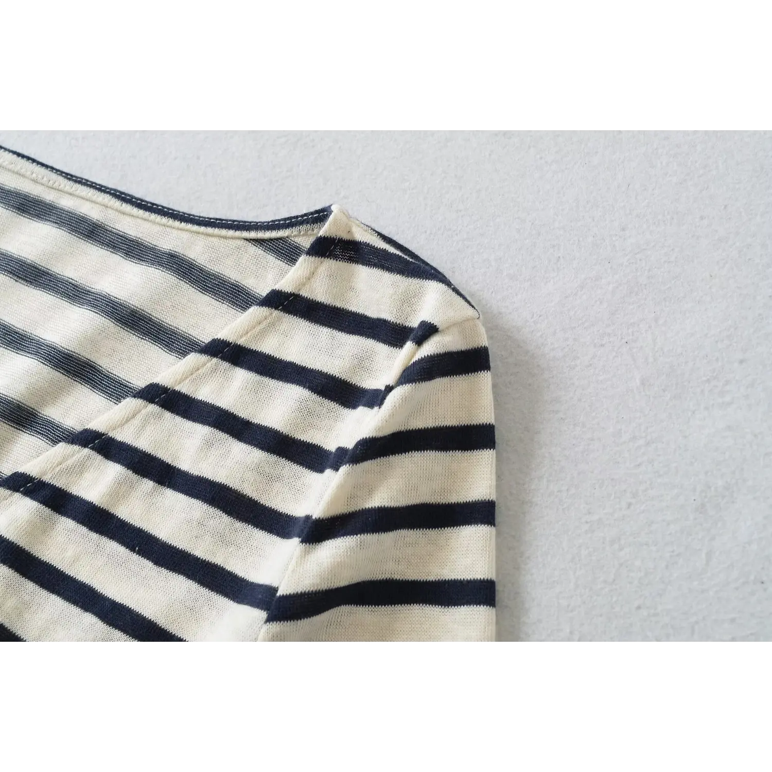 Shoulder and v-neck stitching closeup of white navy striped wrap cropped blouse