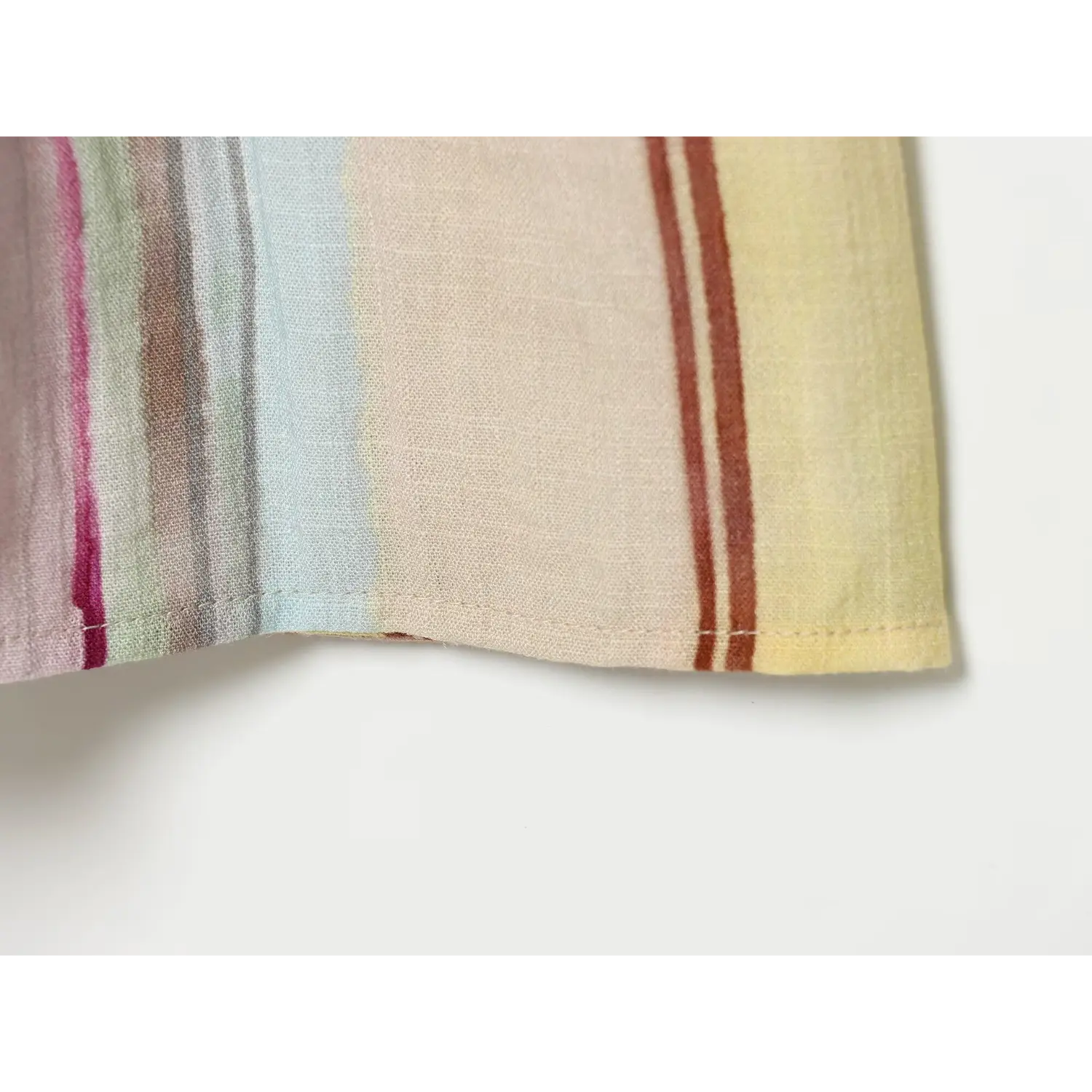 Close‑up of finished bottom hem stitching of colorful striped midi dress