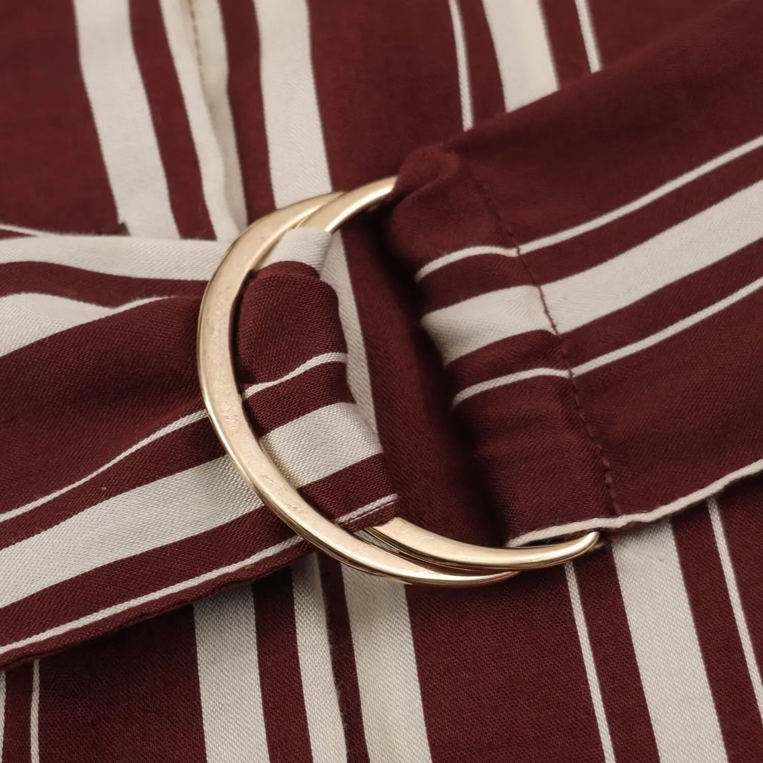 Close‑up of gold D‑ring buckle on matching striped waist belt for shirt maxi dress