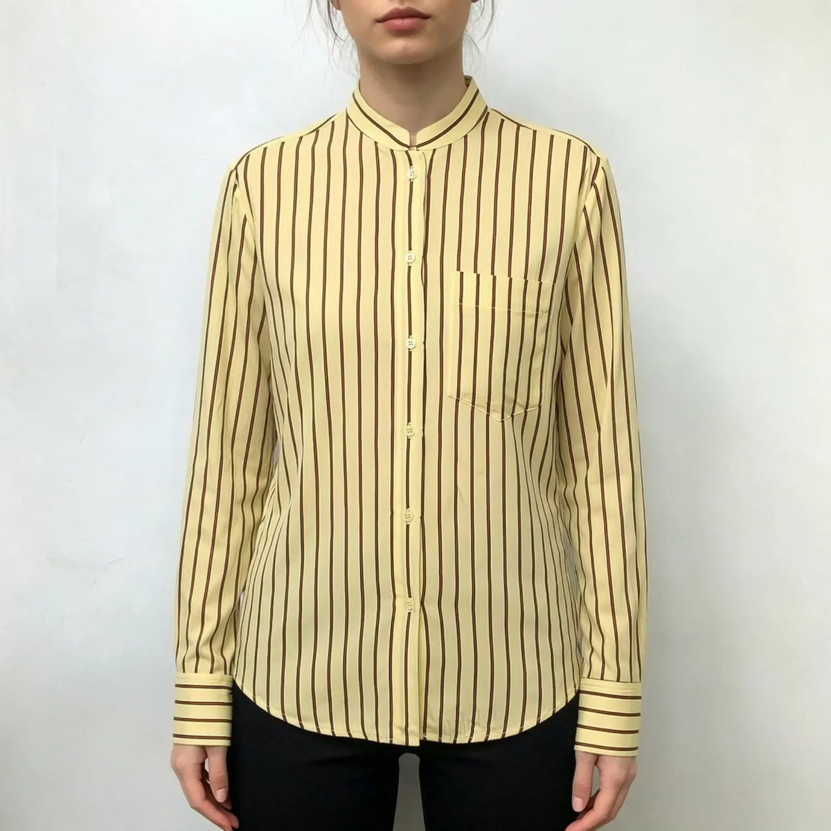 Model wearing pale yellow stripe stand collar shirt with black trousers