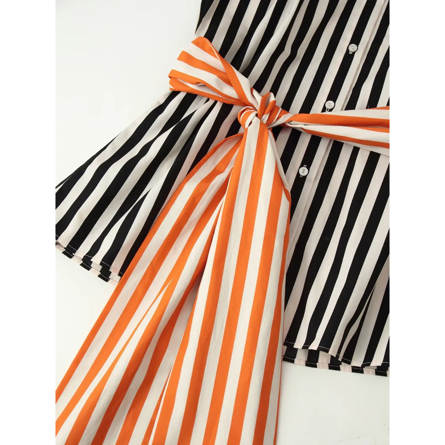 Partial flat shot of shirt waist with fully knotted orange‑white striped long sash, hanging tie ends and front button placket