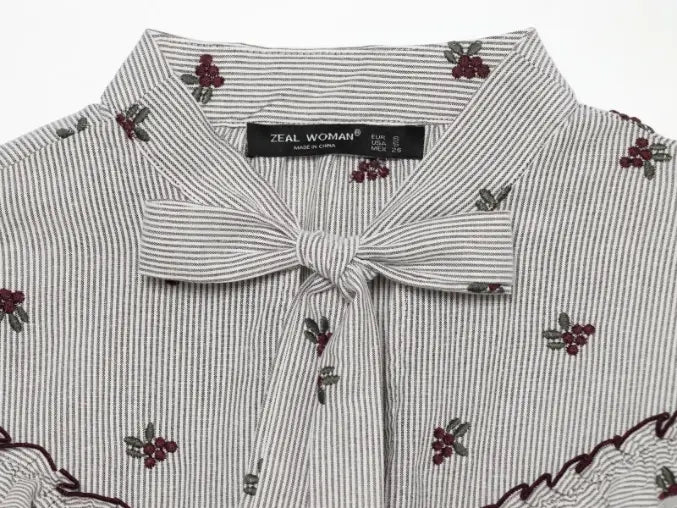 Close-up of striped tie bow and berry embroidery