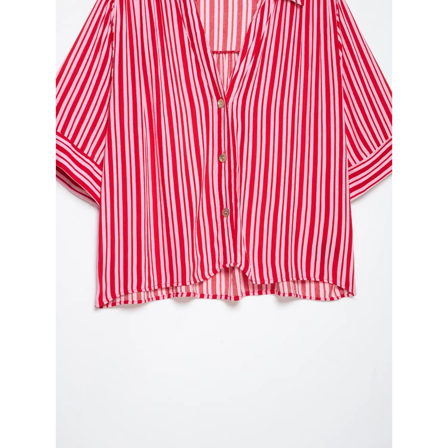 Partial shot of uneven curved front hem, relaxed cropped silhouette on red pink pinstripe blouse