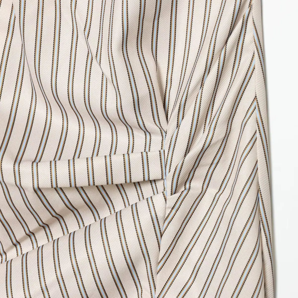 Close-up of the draped fabric on the front of the striped dress, showing the gathered design