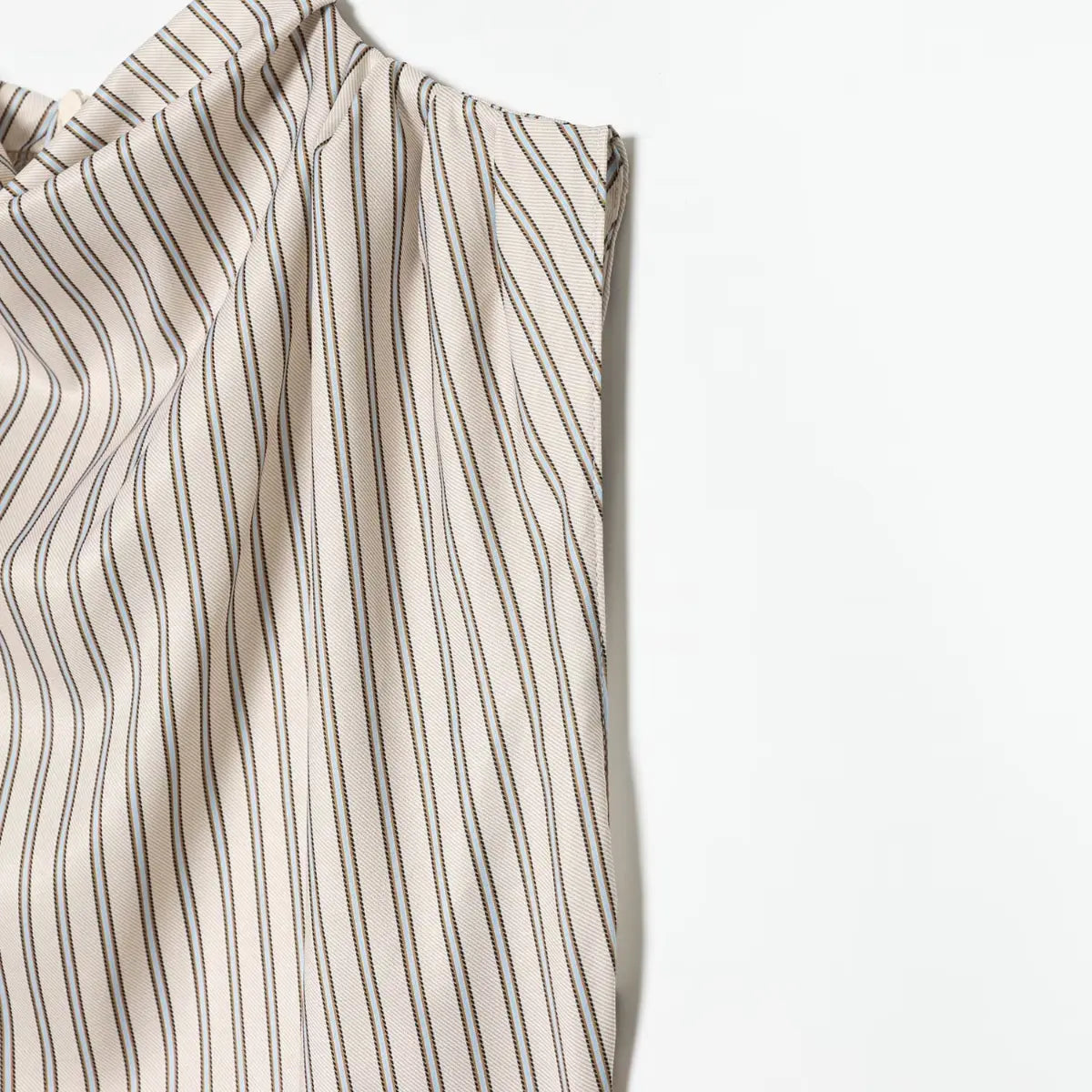 Close-up of the shoulder and fabric texture on the striped dress, showing the draped fabric and stripe pattern