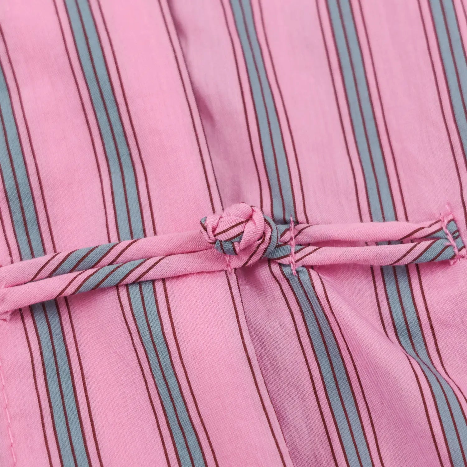 Macro detail handmade covered frog fastener matching stripe textile