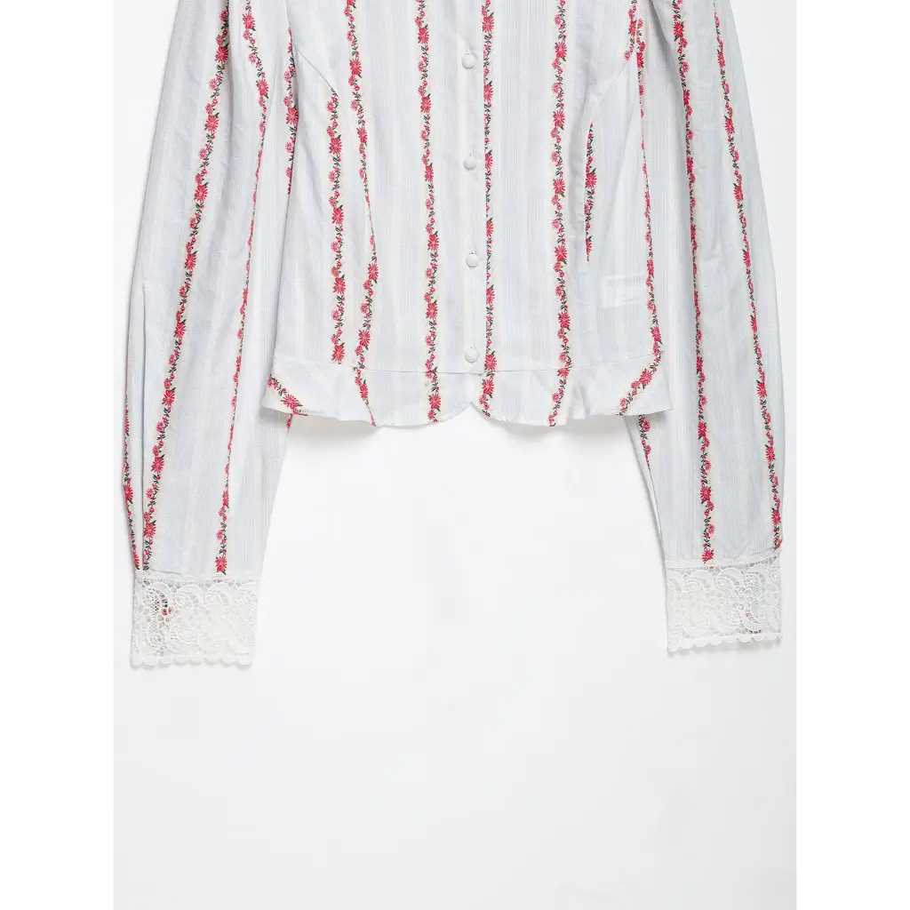 Close-up of cropped hem and lace cuffs flat lay