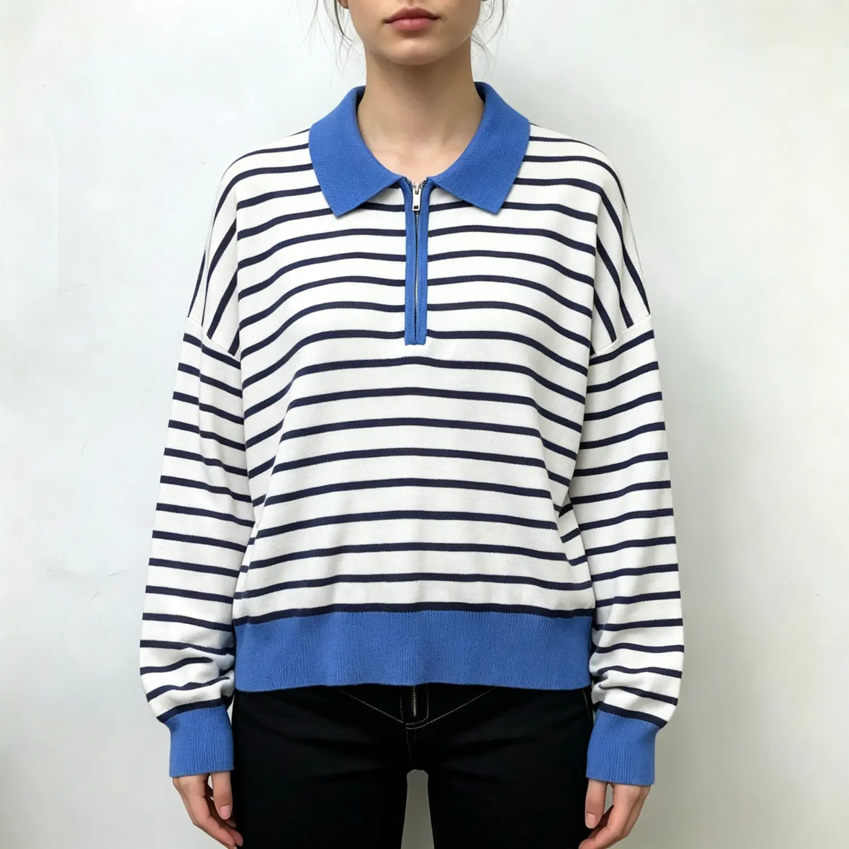 Model wearing striped half zip collared knit top with black trousers